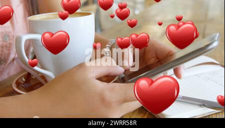 Gros plan d'une paire de mains féminines texturant à côté d'une tasse de café et d'un stylo et d'un cahier Banque D'Images