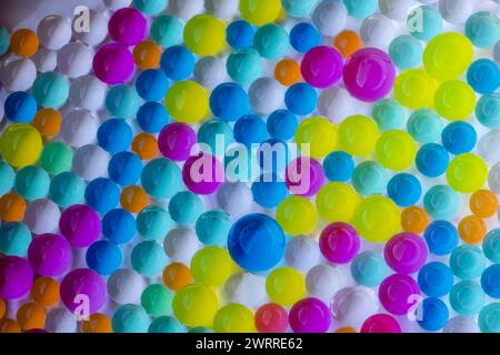 groupe de boules d'hydrogel dans des couleurs vives et différentes tailles sur fond blanc Banque D'Images