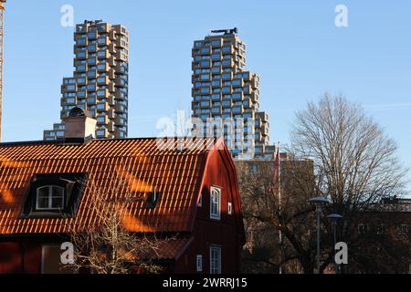 Vieux cottage rouge suédois et quelques-uns des nouveaux gratte-ciel modernes de Stockholm Norra Tornen. En anglais North Towers. Banque D'Images