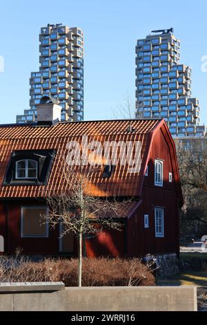 Vieux cottage rouge suédois et quelques-uns des nouveaux gratte-ciel modernes de Stockholm Norra Tornen. En anglais North Towers. Banque D'Images