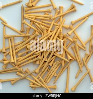 Un petit tas de tees de golf en bambou couleur bois naturel sur une surface blanche Banque D'Images