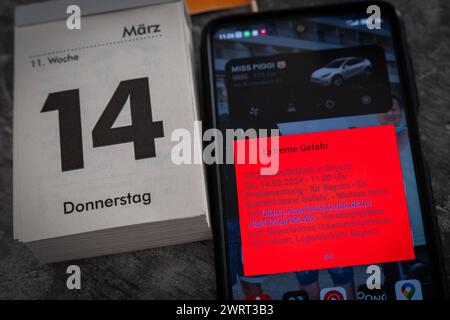 Langweid, Bavière, Allemagne - 14 mars 2024 : alarme de test d'image thématique le 14 mars à 11 heures en Bavière. Smartphone avec le message d'avertissement : danger extrême, sur l'écran *** Themenbild Probealarm AM 14 März um 11 Uhr dans le Bayern. Smartphone mit der Warnmeldung : Extreme Gefahr, auf dem Bildschirm Banque D'Images