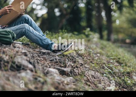 Randonneur perdu avec sac à dos assis près de la rivière et vérifie la carte pour trouver des directions dans la forêt. concept de randonnée et d'aventure. Banque D'Images
