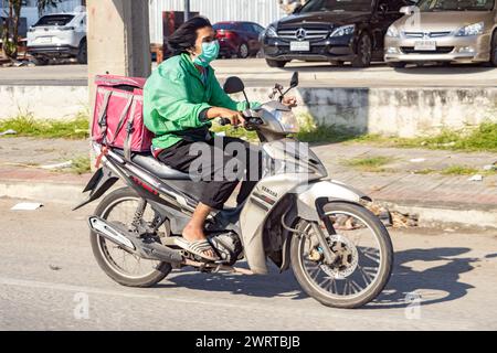 BANGKOK, THAÏLANDE, décembre 05 2023, Un homme conduit une moto avec une boîte de rangement dans la rue Banque D'Images