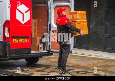 Livraison de colis DPD à Preston, Lancashire. Météo britannique. 14 mars 2024. Début de journée pluvieux pour les acheteurs dans le centre-ville. Aéré avec des vagues de pluie plus lourdes qui balayent. Crédit ; MediaWorldImages/AlamyLiveNews Banque D'Images