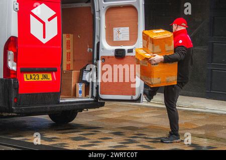 Livraison de colis DPD à Preston, Lancashire. Météo britannique. 14 mars 2024. Début de journée pluvieux pour les acheteurs dans le centre-ville. Aéré avec des vagues de pluie plus lourdes qui balayent. Crédit ; MediaWorldImages/AlamyLiveNews Banque D'Images