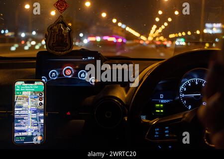 Conduite de nuit avec navigation routière dans un téléphone intelligent relié à un kit mains libres Banque D'Images