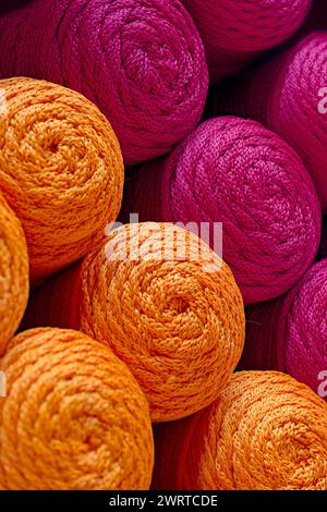 Plusieurs boules de fils orange et rouge, fond textile abstrait Banque D'Images
