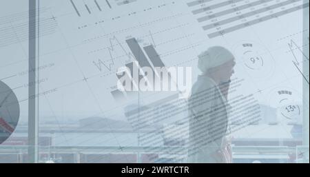 Image de données financières et graphiques sur femme d'affaires biraciale à l'aide d'un smartphone Banque D'Images