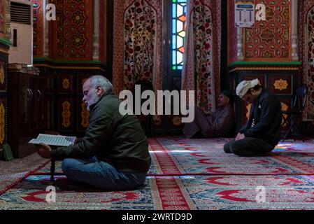 Srinagar, Inde. 14 mars 2024. Un musulman cachemiri lit un extrait du livre sacré islamique Coran à l'intérieur d'un sanctuaire alors que les musulmans du monde entier observent le mois de jeûne islamique Ramadan. Crédit : SOPA images Limited/Alamy Live News Banque D'Images