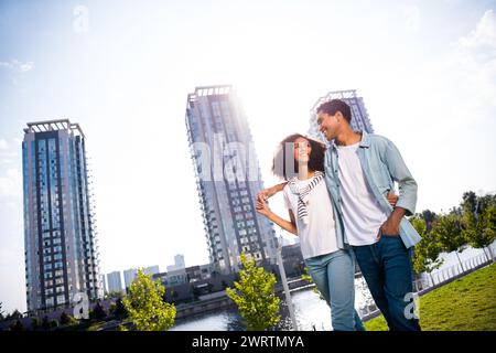 Photo de deux partenaires sucrés idylliques se câlin regarder l'un l'autre bavardant profiter de la promenade du centre-ville moderne à l'extérieur Banque D'Images