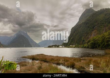 Le spectaculaire Milford Sound, l'un des endroits les plus humides de la planète, est vu sous un ciel typiquement lourd dans le Fiordland, en Nouvelle-Zélande. Banque D'Images