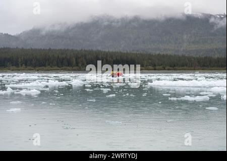 Touristes (méconnaissables) dans une CÔTE DE zodiaque manœuvrant autour des cultivateurs (petits icebergs) à Icy Bay, Alaska, USA Banque D'Images
