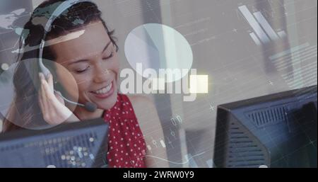 Image de graphiques et de données financiers sur une travailleuse biraciale heureuse de centre d'appels Banque D'Images