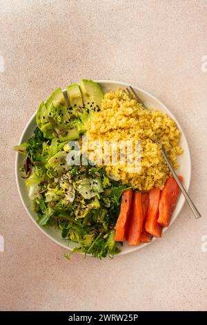 Délicieux petits déjeuners sains, bouillie de bulgur avec du poisson de saumon rouge et un mélange de salade avec des légumes frais, de l'avocat et des graines diverses, un petit déjeuner équilibré sain avec des graisses, des fibres et des protéines Banque D'Images