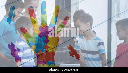 Image d'une main colorée sur des enfants et un homme utilisant des appareils électroniques Banque D'Images