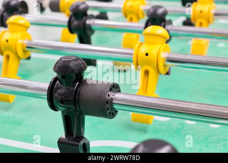 Jeu de table de baby-foot avec figurines en plastique et tiges métalliques vue à angle bas, mise au point sélective isolée. Jeu populaire de football de table joué dans le monde entier. Banque D'Images