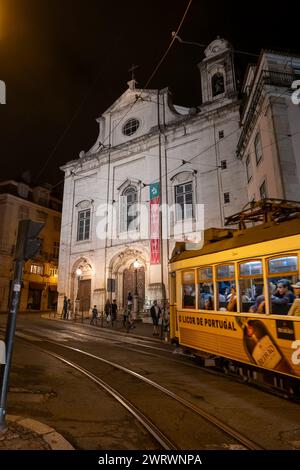 Lisbonne, Portugal - 15 octobre 2023 : église Sainte-Marie-Madalena (portugais : Igreja da Madalena) et tram emblématique NR 28 la nuit. Banque D'Images