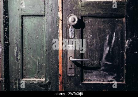 Photo d'une vieille porte grungy obsolète et ombragée d'horreur abandonnée. Banque D'Images