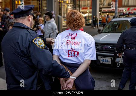 NEW YORK, NEW YORK - 14 MARS : escorte par la police des manifestants pro-palestiniens menottés hors du bâtiment du New York Times lors d'une action critiquant la couverture par le journal de la guerre Israël-Hamas le 14 mars 2024 à New York. Les manifestants ont bloqué les entrées de sécurité à l'intérieur du hall du siège du Times pendant près de deux heures, ce qui a entraîné environ 100 arrestations. (Photo de Michael Nigro/Sipa USA) crédit : Sipa USA/Alamy Live News Banque D'Images