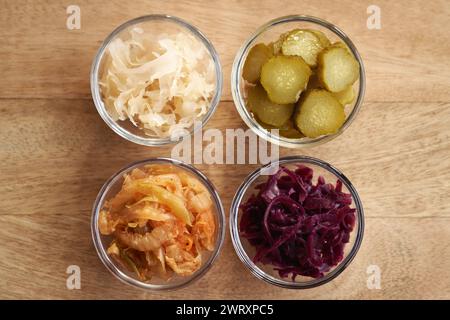 Aliments fermentés et légumes dans des bols - kimchi, choucroute violette et blanche et cornichons Banque D'Images