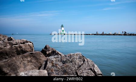 Phare historique de Port Dalhousie Range Front avec des rochers au premier plan et le lac Ontario en arrière-plan. Ciel bleu. Eau bleue. Banque D'Images