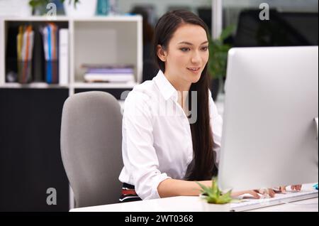 Femme, bureau et pc dans le bureau avec sourire pour le travail avec la saisie de notes, de documents et de calendrier en ligne comme assistant. Administration, personne féminine et Banque D'Images