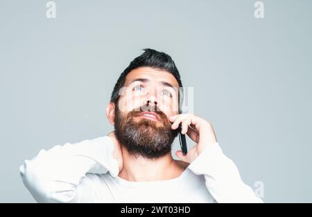 Homme barbu parlant au téléphone. Communications. Banque D'Images