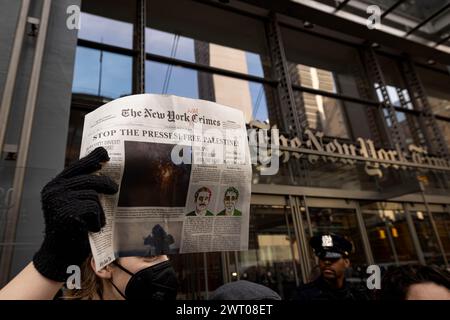 New York, New York, États-Unis. 14 mars 2024. Des manifestants pro-palestiniens tiennent un faux numéro d'un journal qui lit ''les crimes de guerre de New York'' devant les bureaux du New York Times lors d'une action critiquant la couverture par le journal de la guerre Israël-Hamas le 14 mars 2024 à New York. Les manifestants ont bloqué les entrées de sécurité pendant près de deux heures, ce qui a entraîné environ 100 arrestations. (Crédit image : © Michael Nigro/Pacific Press via ZUMA Press Wire) USAGE ÉDITORIAL SEULEMENT! Non destiné à UN USAGE commercial ! Banque D'Images