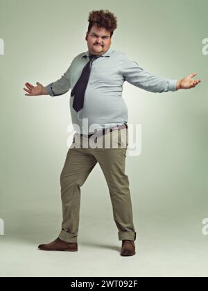 Plus taille, bras et portrait d'homme, excité et bonheur avec énergie en studio avec fond. Adulte, personne masculine et mec avec confiance Banque D'Images