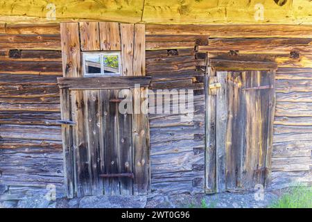 Ancienne grange en rondins altérée avec portes et fenêtres sur une ferme Banque D'Images