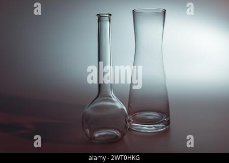 Gros plan de deux vases décoratifs en verre avec rétroéclairage sur fond gris Banque D'Images