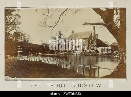 Le Trout Godstow. Henry W. Tunt, photographe (britannique, 1842 - 1922) 1897 une des deux photographies illustrant une carte imprimée de Cassington, Wytham, et les environs le long de la Tamise. La photographie montre une vue du Trout Inn de l'autre côté de la rivière. Le pont Godstow traverse la rivière sur le côté gauche de l'auberge, et une clôture en bois borde la rive au premier plan. (Recto, monture) centre inférieur, image ci-dessous, imprimé à l'encre noire : 'THE TROUT GODSTOW' Banque D'Images