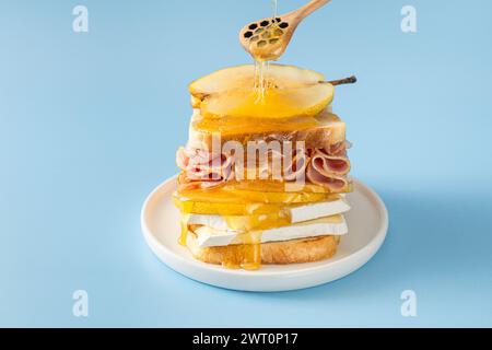 Sandwich poire et jambon arrosé au miel sur bleu Banque D'Images