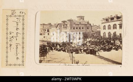 Prog Jean de Luz. Procession de la Fête-Dieu. Edmond de Labrador, photographe (français, actif Bayonne, France des années 1860) vers 1870 Une foule nombreuse de gens se rassemblait sur une place de la ville pour la procession pour la fête du Corpus Christi (Fête-Dieu). La majorité de la foule porte des parapluies. (Recto, monture) partie inférieure centrale, encre noire : 'St Jean de Luz' ; partie centrale droite, texte imprimé rouge : 'EDMOND [space] ST JEAN DE LUZ' ; (verso, monture) partie centrale droite, encre noire : 'procession de la fete/Dieu-/St Jean de Luz/No 1658' ; partie centrale, empreinte rouge : 'PHOTOGRAPHIE/EDMOND/ST JEAN DE LUZ.' ; (recto, page album) l Banque D'Images