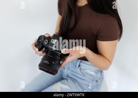 Une fille tenant un appareil photo Canon, vue partielle Banque D'Images