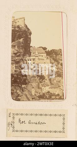 Souvenir du Pelerinage de Roc-Amadour. Vue générale... Belle jeune, photographe vers 1868 vue générale de la commune de Rocamadour, une commune construite sur le flanc d'une colline escarpée. Les bâtiments monastiques sont construits au sommet des falaises abruptes surplombant la ville. (Recto, monture) partie supérieure centrale, texte imprimé en rouge : 'SOUVENIR DU PÉLERINAGE DE ROC-AMADOUR' ; partie inférieure centrale, texte imprimé en rouge : 'vue GÉNÉRALE' ; partie inférieure gauche, texte imprimé en rouge : 'BELLE JEUNE, édit.' ; partie inférieure droite, texte imprimé en rouge : 'a LYON' ; (recto, page album) partie inférieure centrale, image inférieure, encre noire sur étiquette papier blanc : 'e/198 [espace] Roc Amadour.'; Banque D'Images