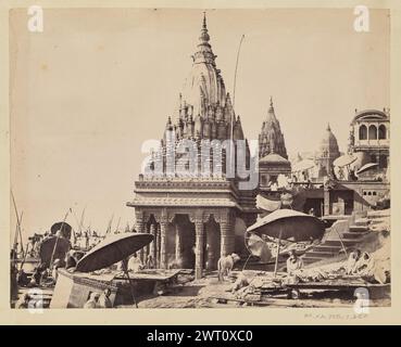 Temple de Ratneshwar Mahadev. Francis Frith & Co, photographe des années 1850–1890 vue du temple Ratneshwar Mahadev sur la rive du Gange. Des groupes de personnes, certains sous de grands parapluies tissés, se rassemblent autour du temple, sur les marches des ghats devant lui, et le long du bord de l'eau. Plusieurs autres temples sont visibles sur le paysage en pente autour du bâtiment. (Recto, impression) en bas à gauche, écrit à la main dans le négatif : '3031. TEMPLE : BENARES' Banque D'Images