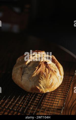 Le pain au levain frais est assis sur la grille de refroidissement sur la table de cuisine Banque D'Images
