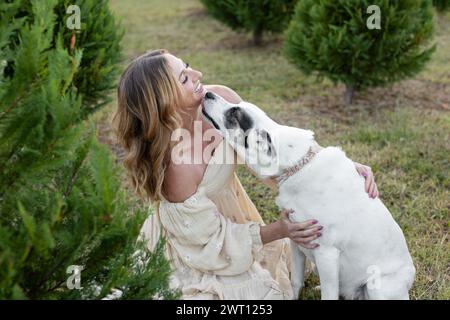 Baiser d'animal de compagnie sincère dans une ferme d'arbre de Noël dynamique Banque D'Images