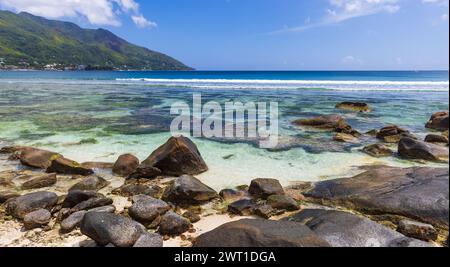 Vue côtière de la plage de beau Vallon, Seychelles. Photo de paysage naturel avec des roches humides prises un jour ensoleillé d'été Banque D'Images