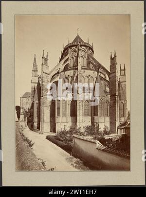 Cathédrale de Bourges, abside. Inconnu, photographe vers 1865–1886 extérieur de l'abside d'une cathédrale. Le bâtiment est rond avec trois niveaux, culminant dans un petit toit pointu. Le niveau inférieur est bordé de tours courtes avec des toits spiralés. Un chemin de terre mène à l'abside et est bordé d'un côté par un jardin clos. Banque D'Images