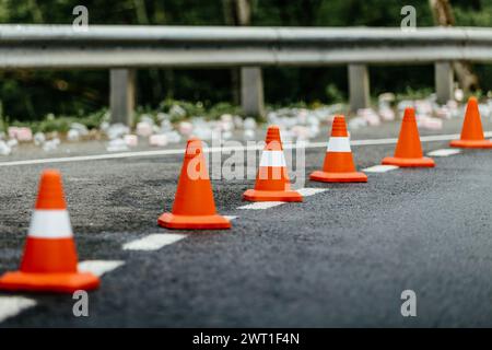 six cônes orange de circulation debout en rangée sur la route de montagne Banque D'Images