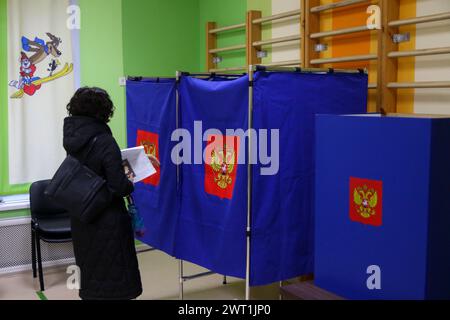 Saint-Pétersbourg, Russie. 15 mars 2024. Une femme vue entrer dans une cabine de vote dans un bureau de vote alors que le vote commence pour l'élection présidentielle russe de 2024. Quatre candidats participent aux élections : le leader du LDPR Slutsky, un membre du Parti communiste Kharitonov, l'actuel chef de l'Etat, Poutine auto-nommé et un membre du Nouveau Parti du peuple Davankov. Crédit : SOPA images Limited/Alamy Live News Banque D'Images