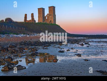 Reculver Towers Kent reflété dans les piscines côtières à Dawn un jour de mars Banque D'Images