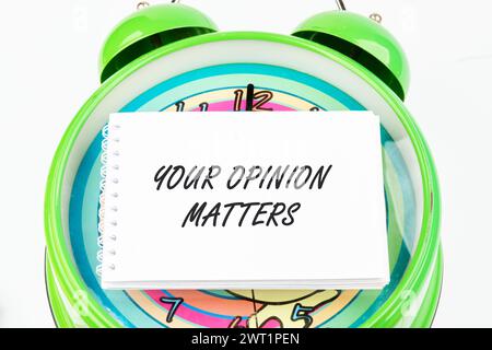 VOTRE OPINION COMPTE LA phrase écrite sur la carte de visite sur le réveil Banque D'Images