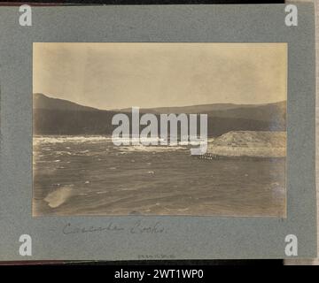 Serrures en cascade. J.F. Ford, photographe (américain, actif dans les années 1900) vers 1900 vue des rapides des Cascades sur le fleuve Columbia. Un mur de pierre artificiel s'étend à partir de l'écluse de cascade, non visible dans le cadre. Les arbres à feuilles persistantes recouvrent le paysage en arrière-plan. (Recto, monture) centre inférieur, en dessous de l'impression, manuscrit à l'encre noire : 'Cascade Locks' en bas à droite, en dessous du coin droit de l'impression, manuscrit à l'encre noire : '15' Banque D'Images