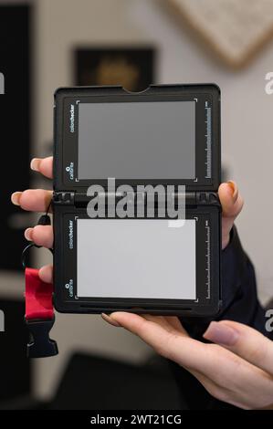 Lviv, Ukraine, 23 février 2024 : une fille tient dans ses mains une carte grise de la marque Calibrite. Femme tient un gros plan du système d'étalonnage X-Rite Banque D'Images