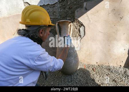 Restaurateur en travaux sur les amphores dans le Schola Armaturarum, la première excavation de Pompéi dans une zone qui n'a jamais été étudiée, après plus de 2 Banque D'Images