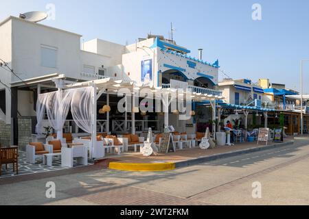 Kos, Grèce - 12 mai 2023 : promenade côtière avec boutiques et restaurants dans la station balnéaire de Kardamena. Île de Kos, Grèce Banque D'Images